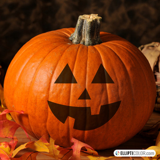 Jack-O'-Lantern face stickers on a pumpkin, autumn leaves, and a dark background