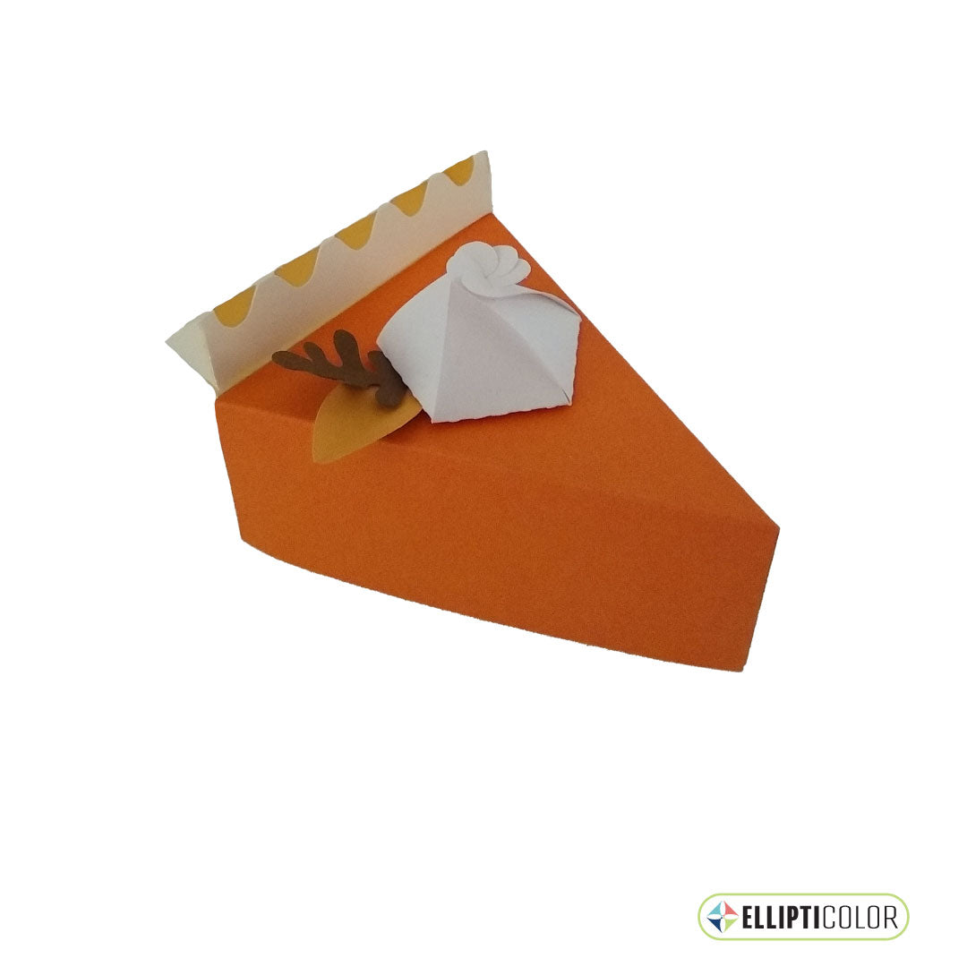 Paper craft pumpkin pie shaped box garnished with whipped cream and fall leaves.