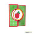 Card with a red apple design on a green polka dot background