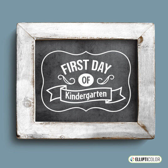 A framed chalkboard sign with a distressed white wooden frame, featuring the text 'First Day of Kindergarten' in white vinyl.