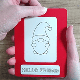 Hand pulling tab on a  red framed Magic Slider Card with a gnome design and 'Hello Friend' text.