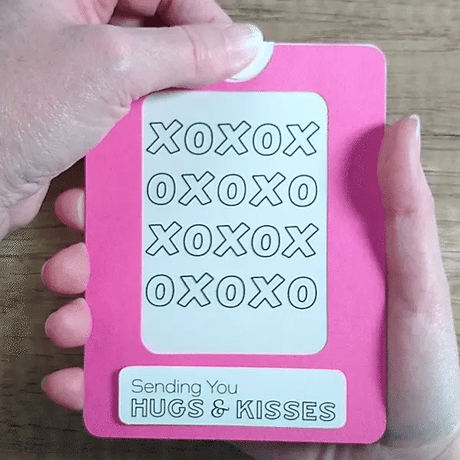 Pink Magic Slider Card with 'XOXO' text and 'Sending You Hugs & Kisses' message held by a hand.