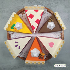 Decorative paper craft pie boxes on a wooden board with a gray background