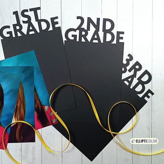 Black insert frames topped with '1st Grade', '2nd Grade', and '3rd Grade' text, scattered photos, and ribbon on a wooden surface